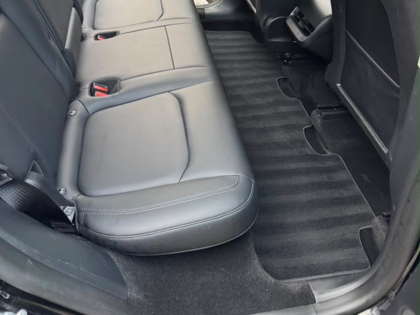 Rear seats and footwell after an interior clean — vacuumed carpet and wiped leather