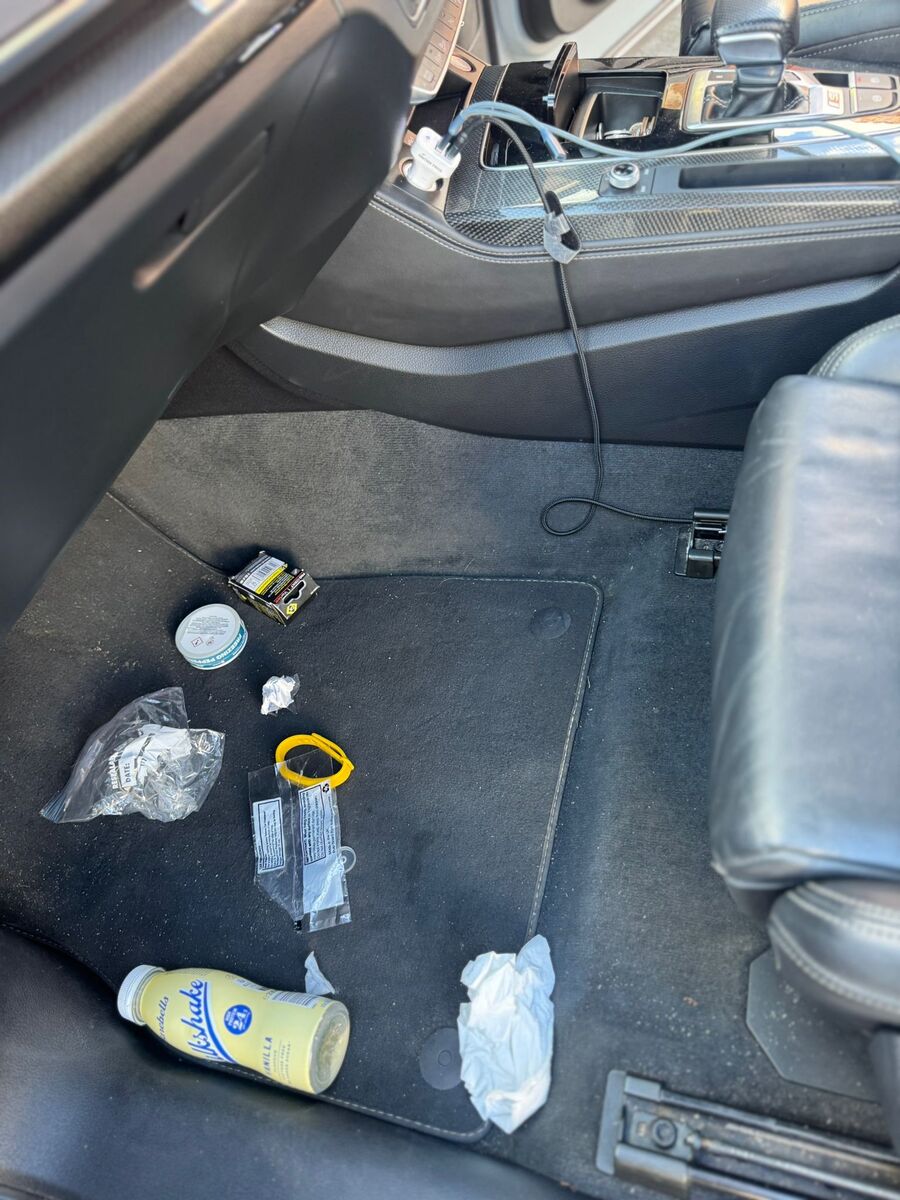Car footwell littered with rubbish before cleaning